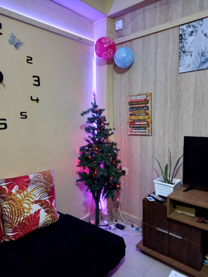 A room decorated for Christmas mit a tree and some balloons
